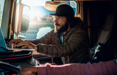 black man and bearded man in semi truck cab