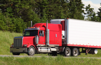 red semi truck with white trailer on road