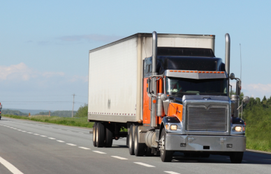 orange and navy semi truck on road