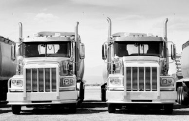 black and white photo of vintage semi trucks