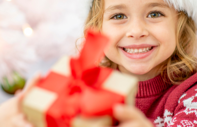 little girl holding out holiday gift