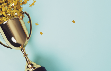 confetti stars spilling out of gold trophy on light blue background