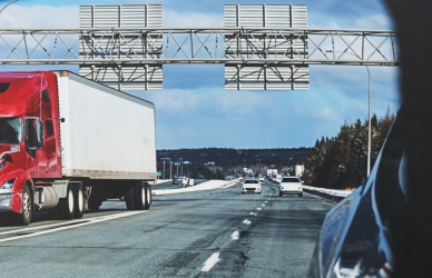 semi truck reflection in car side view mirror