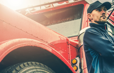 man standing next to red semi truck