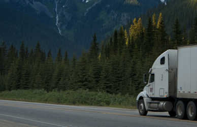 semi truck on road with mountains in background