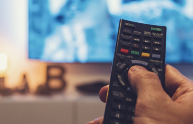 man holding remote with tv in background