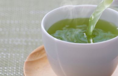 green tea being poured into white tea cup