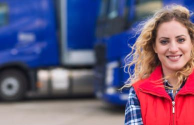 woman standing in front of parked semi trucks