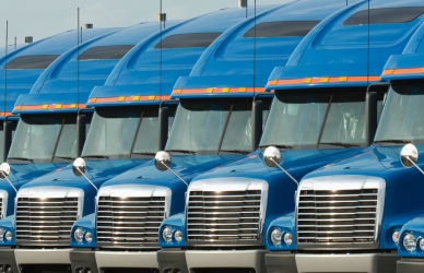 line of blue semi trucks parked in lot