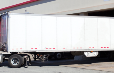 red semi truck backed into loading dock