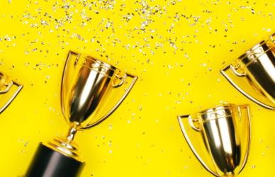 trophies and confetti on yellow background