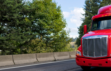 red semi truck with white trailer on road
