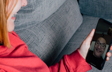 woman sitting on couch talking to man on facetime