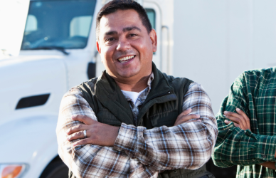 two men standing in front of semi truck
