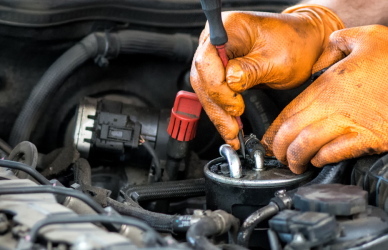 mechanic wearing orange gloves working on engine