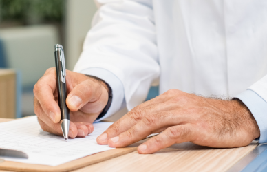 doctor filling out paperwork on clipboard