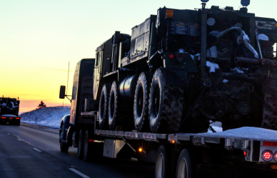 flatbed semi truck driving into sunset