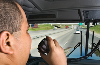 truck driver in cab talking on cb radio