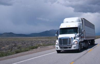 white semi truck on road on cloudy day