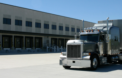 semi truck parked behind commercial loading dock area