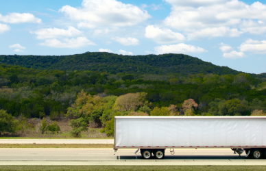 red semi truck with white trailer on road