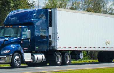 blue semi truck pulling white trailer