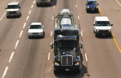 highway with cars and semi trucks in summer with green on sides of road