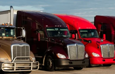 variety of semi trucks parked in a truck parking lot