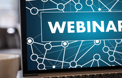 laptop open with webinar on screen and cup of coffee nearby