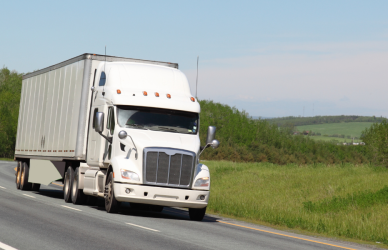 white semi truck with white trailer on road