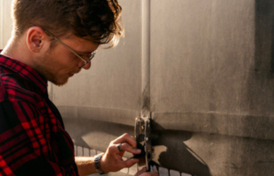 young man standing beside semi truck