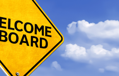 yellow welcome aboard road sign with a blue sky in the background