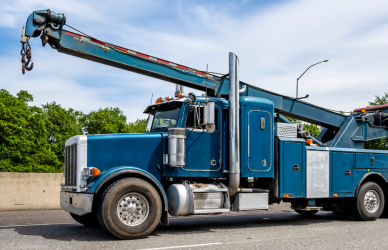 blue semi truck tow truck towing white semi truck