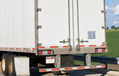 Semi truck parked on side of road next to no parking sign