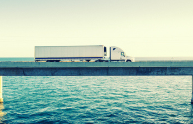 semi truck driving over bridge
