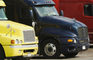 a variety of semi trucks parked in a parking lot