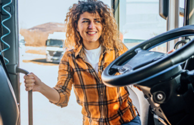 Young woman getting into semi truck cab