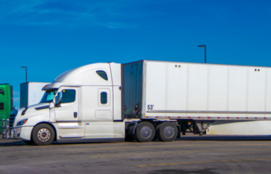 two semi trucks parked in parking lot