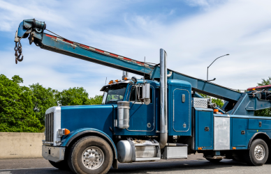 semi truck being towed by blue tow truck
