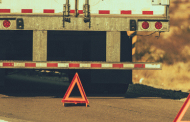 semi truck on side of road with triangles