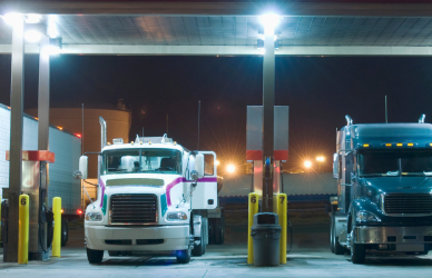 semi trucks parked under canopy at fuel island truck stop