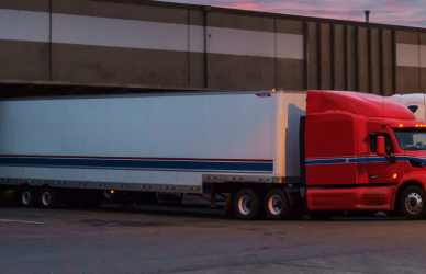 red and blue semi trucks backed up to commercial loading dock