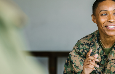 black woman dressed in military uniform talking in a group setting