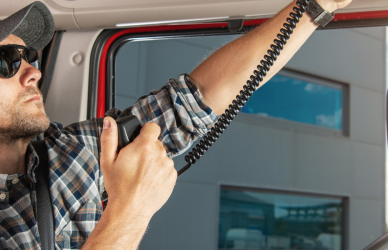 semi truck driver in cab talking on CB