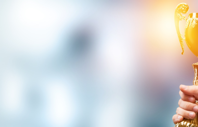 trophy in hand being held high on blurry background