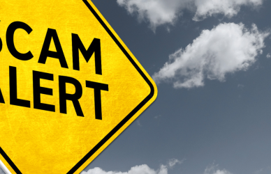 bright yellow scam alert sign on dark sky background