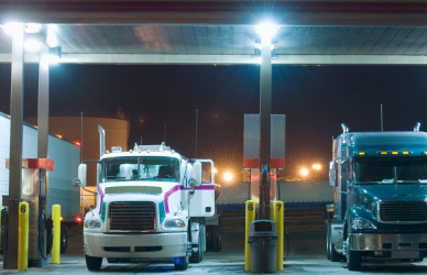 semi trucks parked under fuel island at truck stop