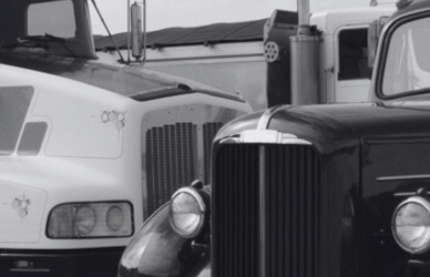 black and white photo of older and newer semi truck