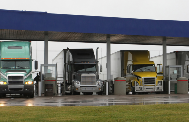 semi trucks parked under canopy at truck stop