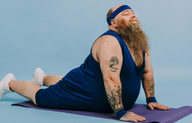man with long beard and tattoos doing yoga